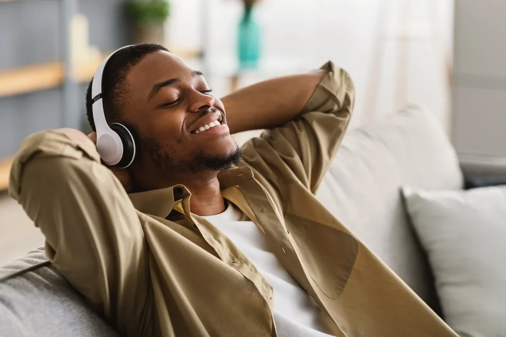 Man Listening To Music Wearing Earphones At Home