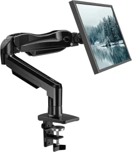 Black heavy-duty single monitor arm with mechanical articulation, holding a flat-screen display showing a landscape image, secured with a desk C-clamp base.