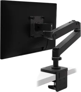 Ergonomic matte black monitor arm attached to the back of a PC monitor and securely clamped to a white office desk surface.